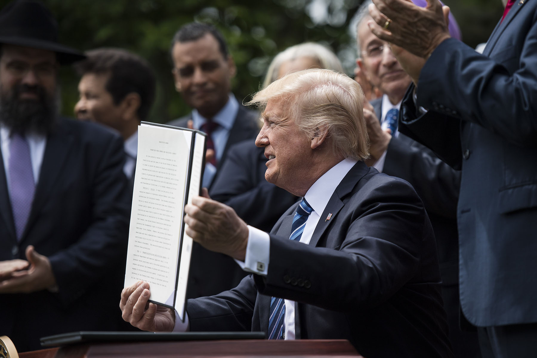 President Trump signs an executive order in the Rose Garden of the White House.