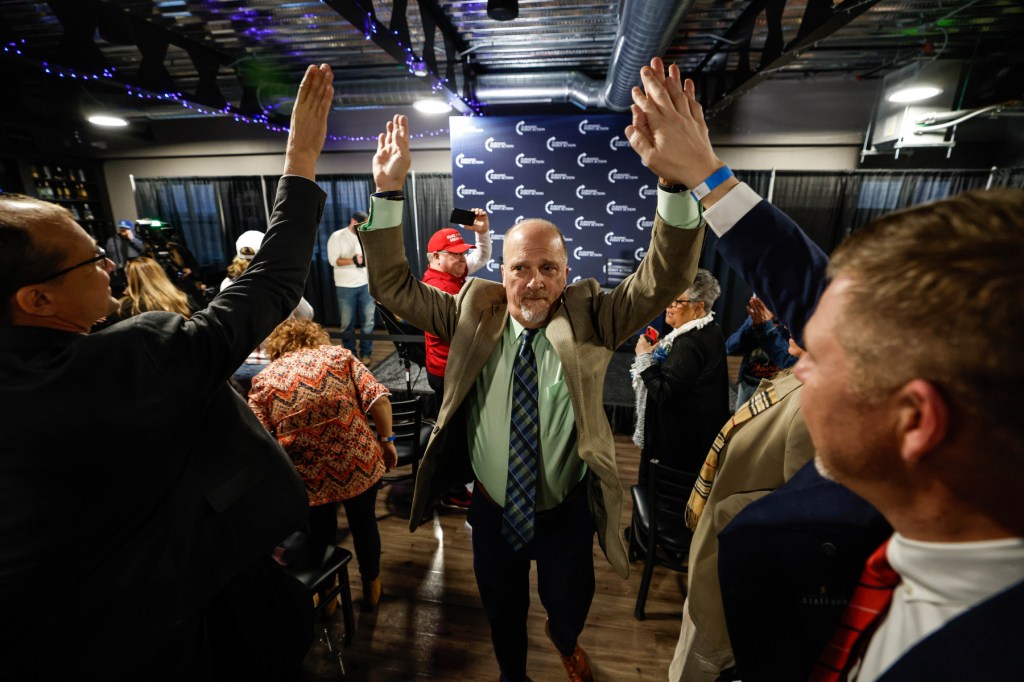 A man high fives people as he walks past them.