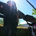 People carry mock black coffins down the street.