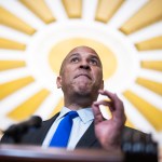Senator Cory Booker gestures at a podium.