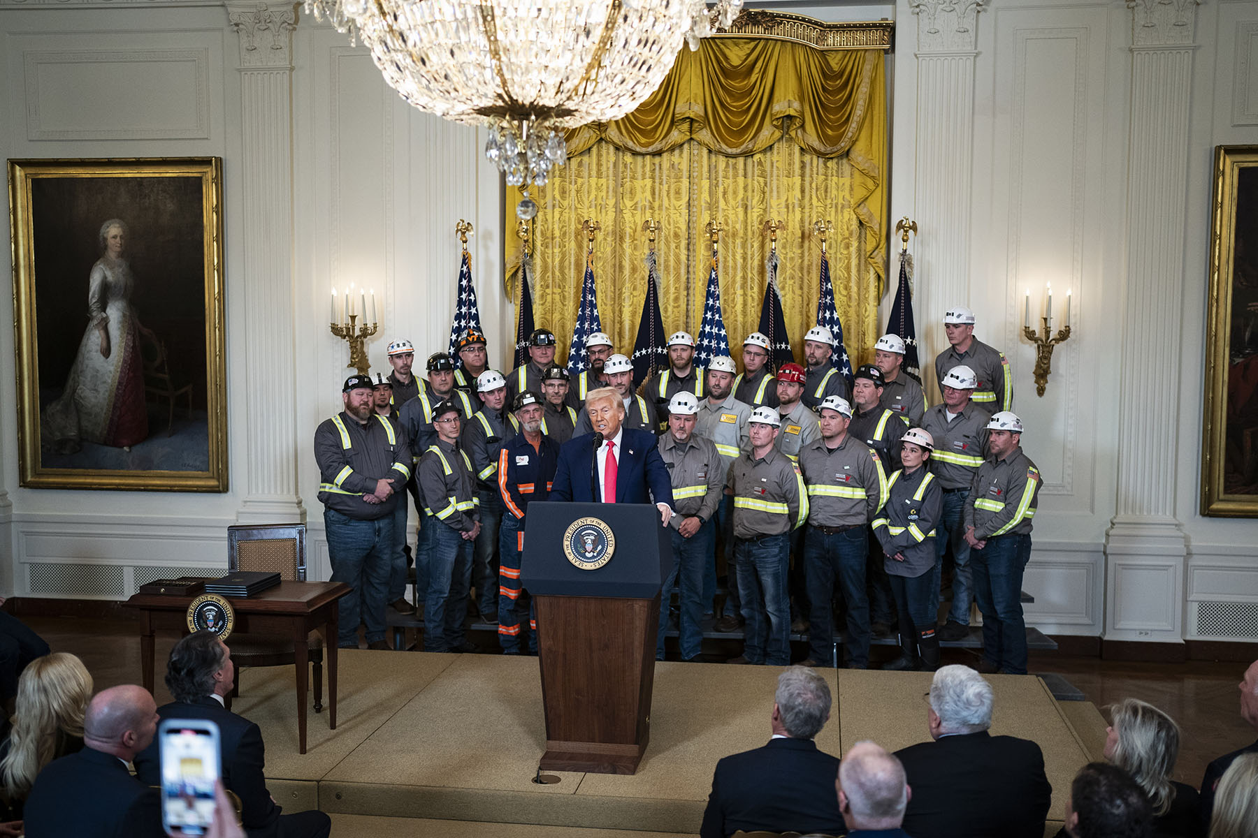 Coal miners listen as President Trump speaks and signs executive orders about coal production in the East Room at the White House.