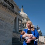 Rep. Brittany Pettersen holds her one-month old baby as she departs during a series of votes at the Capitol.