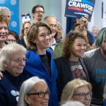 Judge Susan Crawford, wearing a blue jacket, stands with supporters