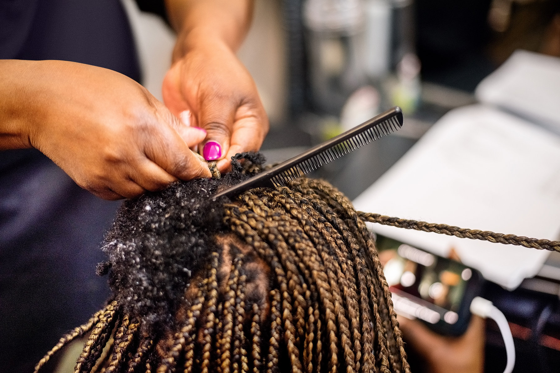 Closeup of a woman braiding hair.