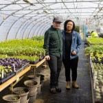 Two people stand for a portrait on their farm.