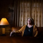 Cheryl Thompson sits on a couch as she poses for a portrait near her home.