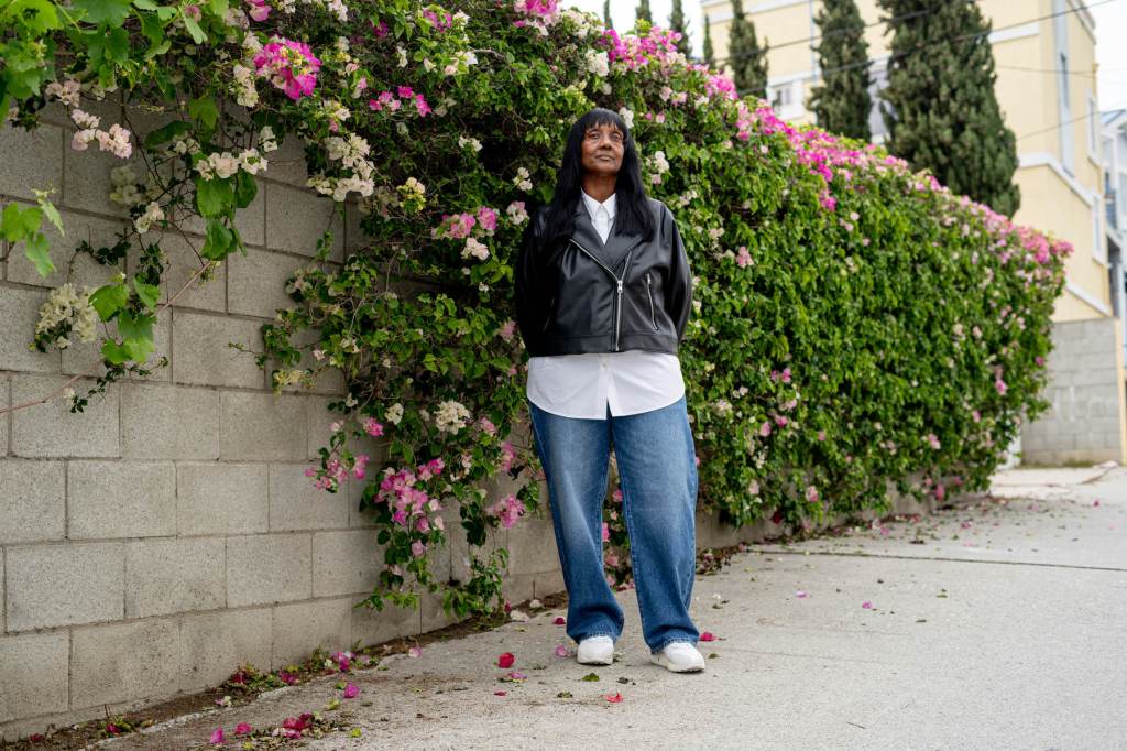Michelle West stands near a wall of flowers.